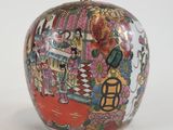 un vase en forme de pomme sur lequel est représentée une femme
