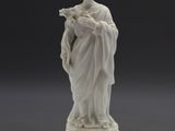 une statue blanche représentant une femme tenant un oiseau, posée sur un socle