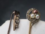 a pair of earrings that are sitting on top of a white object