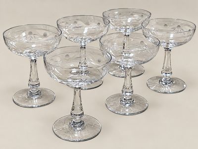 six verres à vin vides posés sur une surface blanche