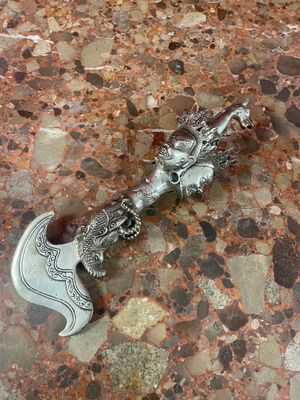 a silver dragon head on top of a silver axe