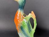 a small vase with a bird on it on a black surface