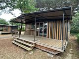 a small wooden cabin with a porch and a covered porch
