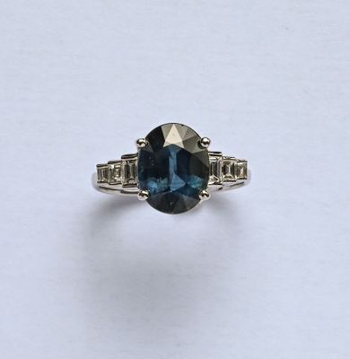 Bague en or gris 18K (750/oo) centrée d'un saphir ovale somb…