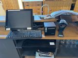 a desk with a computer, keyboard, mouse, and other items on it