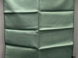 an up close view of a green pillow on a gray wall