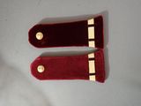 two red velvet cases with gold buttons on them on a white surface