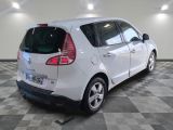 a picture of a small white car parked in a garage