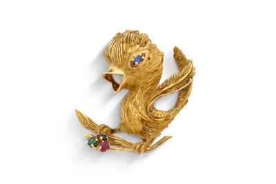 une image représentant une broche en forme d'oiseau en or, ornée de pierres colorées