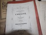 un livre posé sur une table, à côté d'une pile de livres