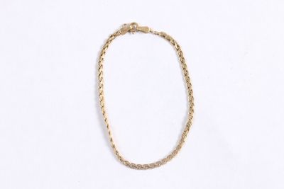 gros plan d'un collier en or sur fond blanc