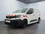 La camionnette blanche est garée dans une grande pièce décorée de rayures rouges et blanches.