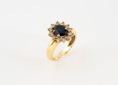 gros plan d'une bague en or avec un saphir et des diamants