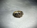 a close up of a gold ring with a flower design on it