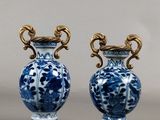 pair of blue and white vases sitting on top of a table