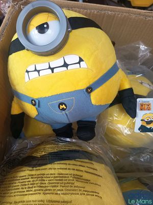 une petite peluche dans une boîte, avec une étiquette dessus