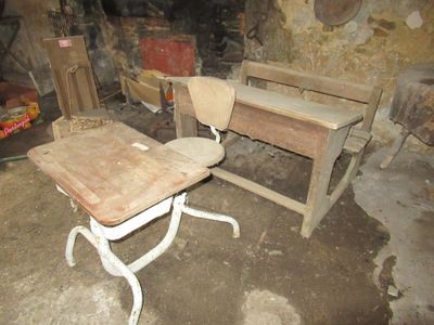 un bureau et une chaise en bois dans une pièce avec un mur en pierre