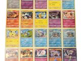 les cartes pokémon sont alignées sur une surface blanche