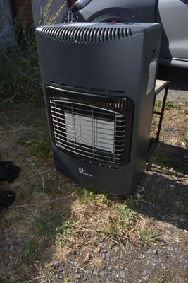 un radiateur noir posé par terre à côté d'une voiture