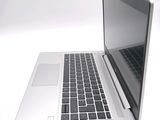 a silver laptop computer sitting on a white surface