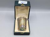 une coupe ancienne en métal argenté, dans un coffret posé sur une table