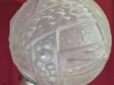 une boule de verre blanche posée sur un tissu rouge