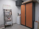 an orange cabinet in the corner of a room next to a white refrigerator
