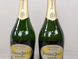 two bottles of champagne sitting next to each other on a table