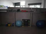 dimly lit office cubicle with exercise equipment and a blue ball