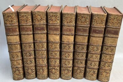 six vieux livres alignés sur une surface blanche