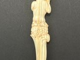 a carved ivory figurine of a woman holding a basket