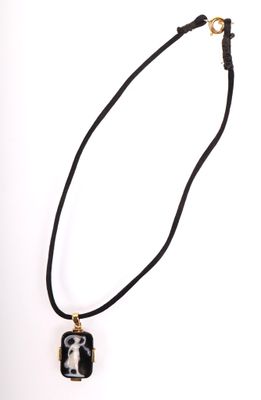 pendentif en verre noir et blanc, monté sur un cordon noir muni d'un fermoir doré