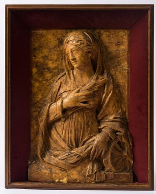 une sculpture en bois représentant une femme tenant un bébé dans ses bras, dans un cadre en bois