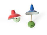 two colorful lamps on a white surface with one red and the other green