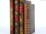 three books are stacked on top of each other on a white surface