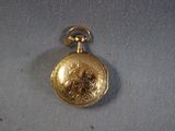 an image of a gold pocket watch on a white cloth