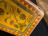 a yellow box with a floral design on it next to a brown bag