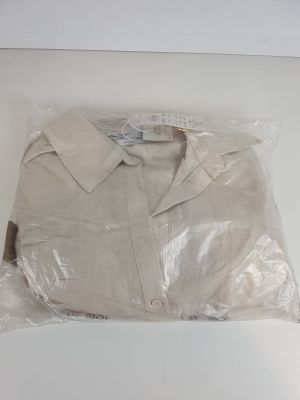 une chemise blanche emballée dans du plastique, posée sur une table