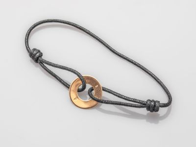 a close up of a bracelet with a coin on it
