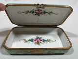 someone is holding a small box with a flower design on it