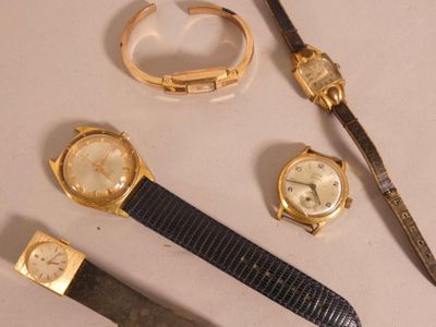 trois montres différentes et un couteau posés sur une table