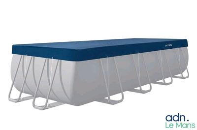 une image représentant une piscine rectangulaire recouverte d'une bâche bleue