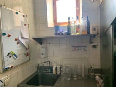 une petite cuisine équipée d'un évier et d'un réfrigérateur
