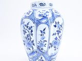 a blue and white vase sitting on a white surface
