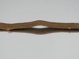 a gold hair clip on a white surface