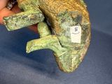 a person holding a clay lizard on a blue surface