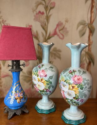 trois vases posés sur une table avec une lampe rouge