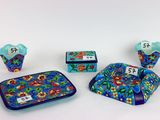 trois pièces en céramique bleues et rouges ornées de fleurs et de chiffres