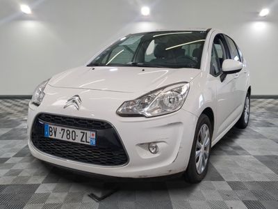 la petite voiture blanche est garée sur un sol en damier
