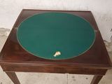 a small table with a green top and a wooden base